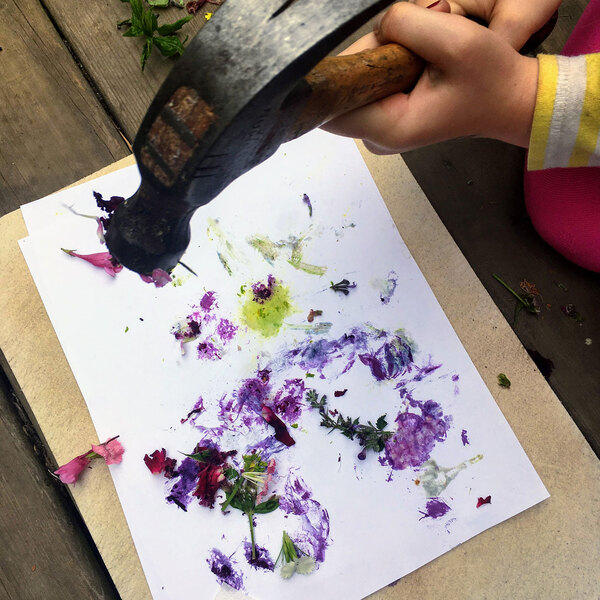 Hammer smashing flowers on paper