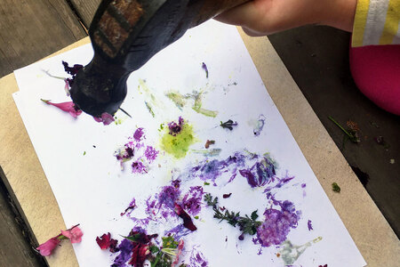 Hammer smashing flowers on paper