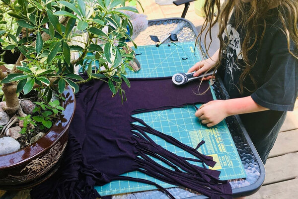 Little girl cuts shirt on cutting mat