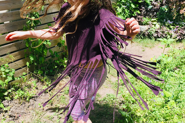 Little girl spins wearing tassle shirt