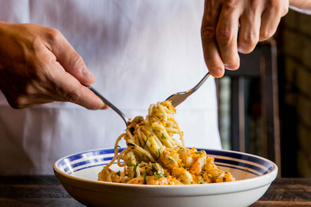 Chef mixing a bowl of pasta